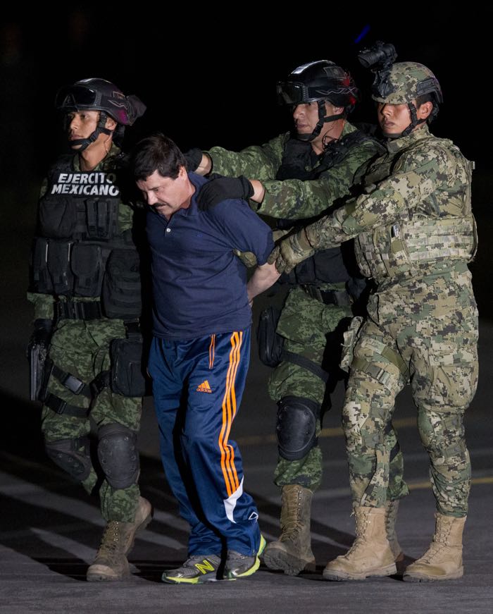 Mexican drug lord Joaquin "El Chapo" Guzman is escorted by soldiers and marines to a waiting helicopter, at a federal hangar in Mexico City, Friday, Jan. 8, 2016. The world's most wanted drug lord was recaptured by Mexican marines Friday, six months after he fled through a tunnel from a maximum secuirty prison in a made-for-Hollywood escape that deeply embarrassed the government and strained ties with the United States. (AP Photo/Rebecca Blackwell)