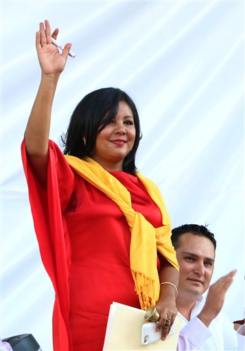 In this Friday, Jan. 1, 2016 photo, Gisela Mota waves during her swearing in ceremony as mayor of Temixco, Morelos State, Mexico. The Morelos state Public Security Commission says attackers invaded Mota's house on Saturday morning and killed her. (AP Photo/Tony Rivera)