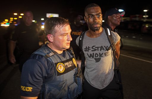 Police arrest activist DeRay McKesson during a protest along Airline Highway, a major road that passes in front of the Baton Rouge Police Department headquarters Saturday, July 9, 2016, in Baton Rouge, La. Protesters angry over the fatal shooting of Alton Sterling by two white Baton Rouge police officers rallied Saturday at the convenience store where he was shot, in front of the city's police department and at the state Capitol for another day of demonstrations. (AP Photo/Max Becherer)