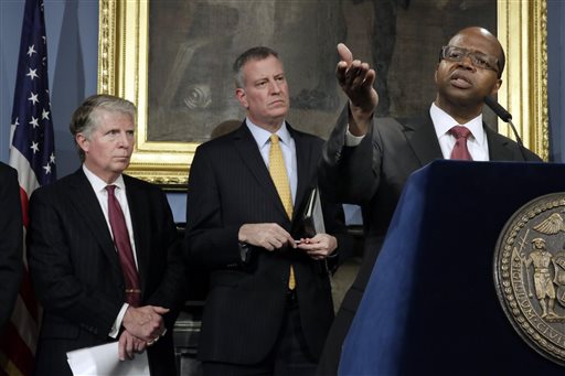 Brooklyn District Attorney Ken Thompson, right, addresses a news conference on gun-related violence in New York's City Hall, Tuesday, Jan. 12, 2016. He is accompanied by Manhattan District Attorney Cyrus Vance Jr., left, and New York Mayor Bill de Blasio. (AP Photo/Richard Drew)