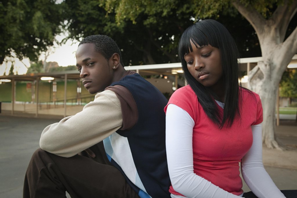 African teenage couple arguing in school yard