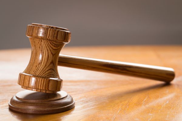 Close-Up Of Wooden Gavel On Table In Courtroom