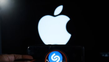 Shazam logo is seen trough a magnifying glass on an android...