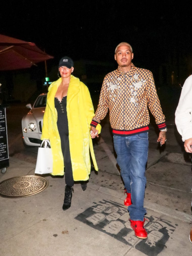 Amber Rose rocks a "slut" hat while holding her man's hand.