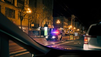 Police car with emergency lights on in downtown district