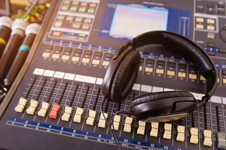 Headphones, microphones, amplifying equipment, Studio audio mixer knobs and faders, background sound mixer. Workplace and equipment sound engineer. Sound acoustic music mixing, selective focus