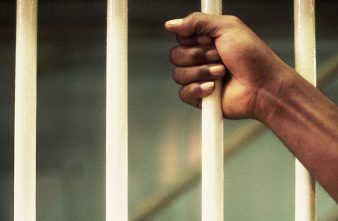 Hand Holding Prison Cell Bar