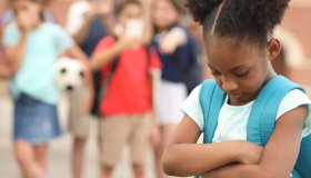 Elementary age, African American girl being bullied at school.