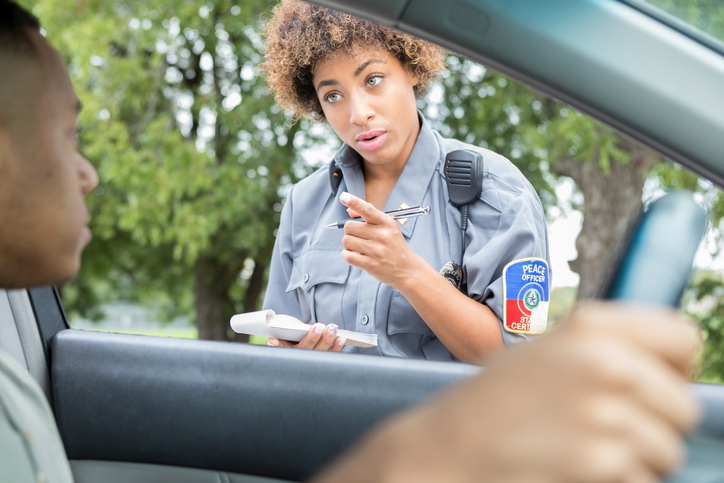 Female police officer discusses traffic laws with driver