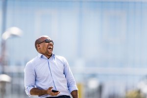 Cheerful African American businessman laughing on the street.