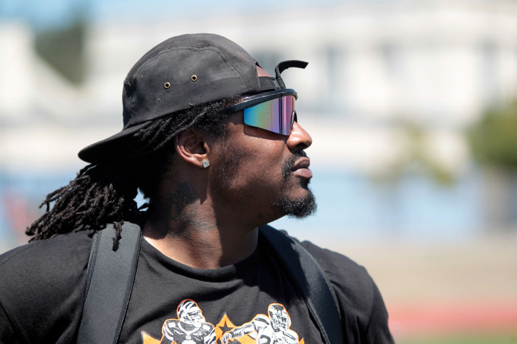 Marshawn Lynch, Seattle Seahawks running back and former Oakland Tech High football star, keeps an eye on the action at the Fam 1st Family Foundation's annual youth football camp at Oakland Tech High School in Oakland, Calif., on Saturday, July 13, 2013.
