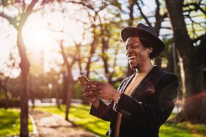 Man using phone in park at sunset