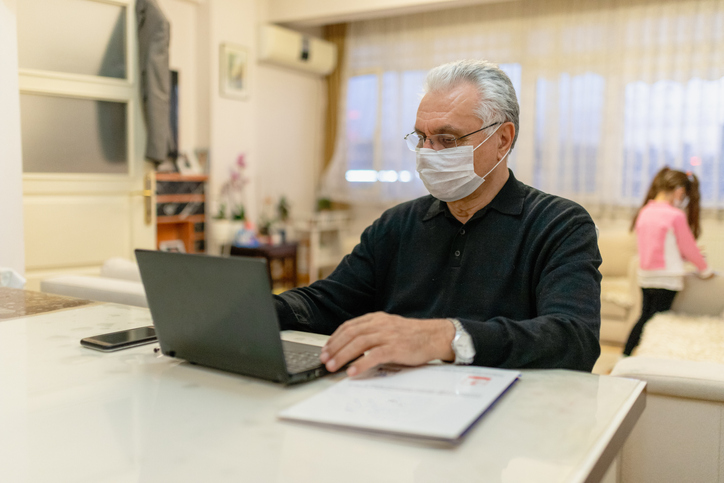 senior man working on laptop at home