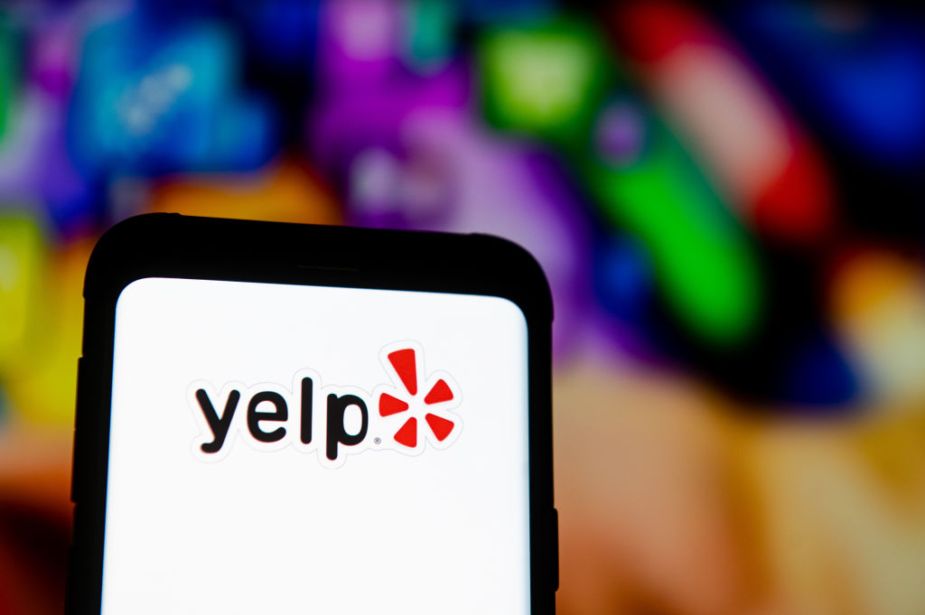 In this photo illustration a Yelp logo seen displayed on a...