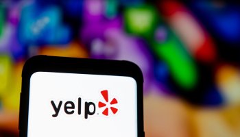 In this photo illustration a Yelp logo seen displayed on a...
