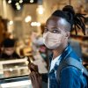 Portrait of young customer with face mask in coffee shop