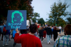 A protester holds a placard while marching during the...