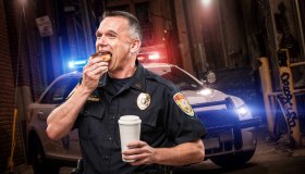 Police Officer Eating Donut in Alley