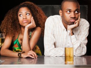 Couple sitting at bar and looking irritated