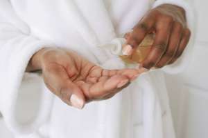 Woman Pours Beauty Product Into Palm of Hand