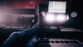 Music producer relaxing with feet up in music recording studio