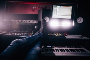 Music producer relaxing with feet up in music recording studio