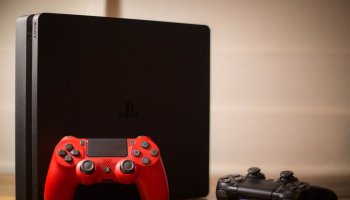 A Sony PlayStation 4 video game console with a red and black...