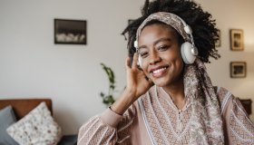 African-American woman is listening to music at home