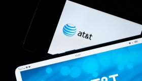 In this photo illustration, AT&T logos seen displayed on...