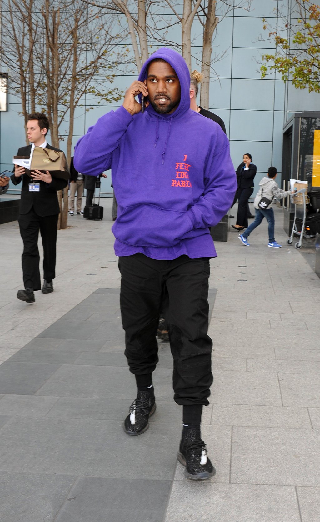 Kanye West arriving at Heathrow Airport all smiles