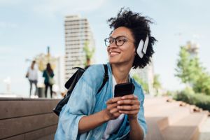 Portrait of a happy girl with headphones using her smartphone