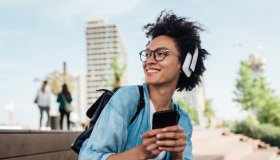 Portrait of a happy girl with headphones using her smartphone
