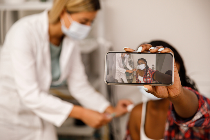 Taking a selfie of getting a COVID-19 vaccine