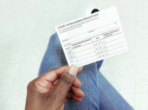 Woman Holds COVID-19 Vaccination Record Card