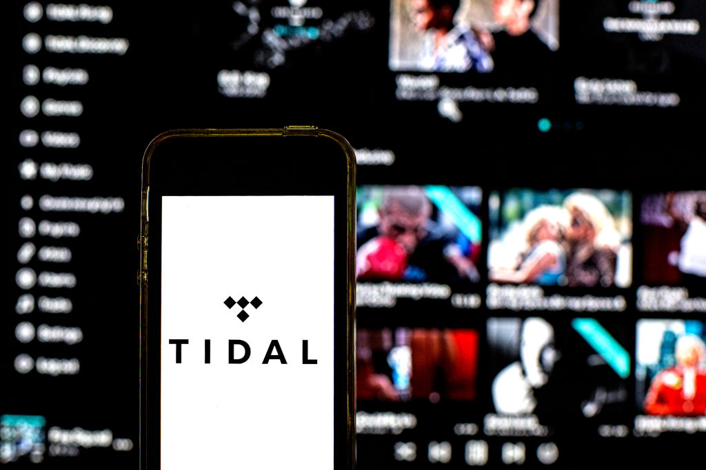 In this photo illustration a Tidal logo seen displayed on a...