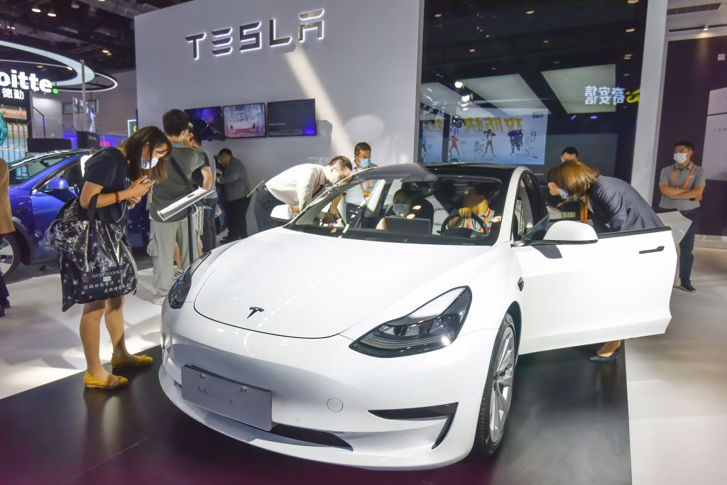 In Tesla's exhibition hall, a Tesla car surrounded by...