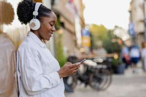 Portrait of young woman outdoors, looking at the phone