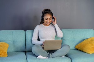 Woman using tablet computer and headphones while relaxing at home