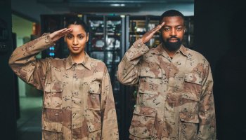 Shot of two soldiers saluting in a server room