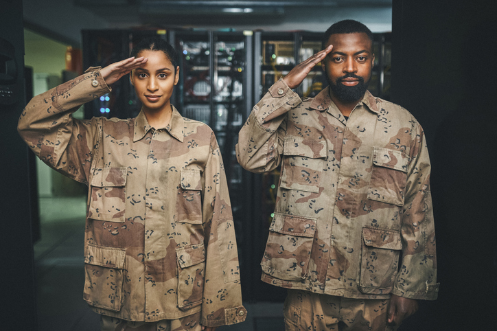 Shot of two soldiers saluting in a server room