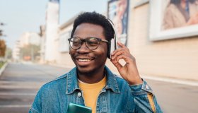 Portrait of a young African American walking and enjoying music