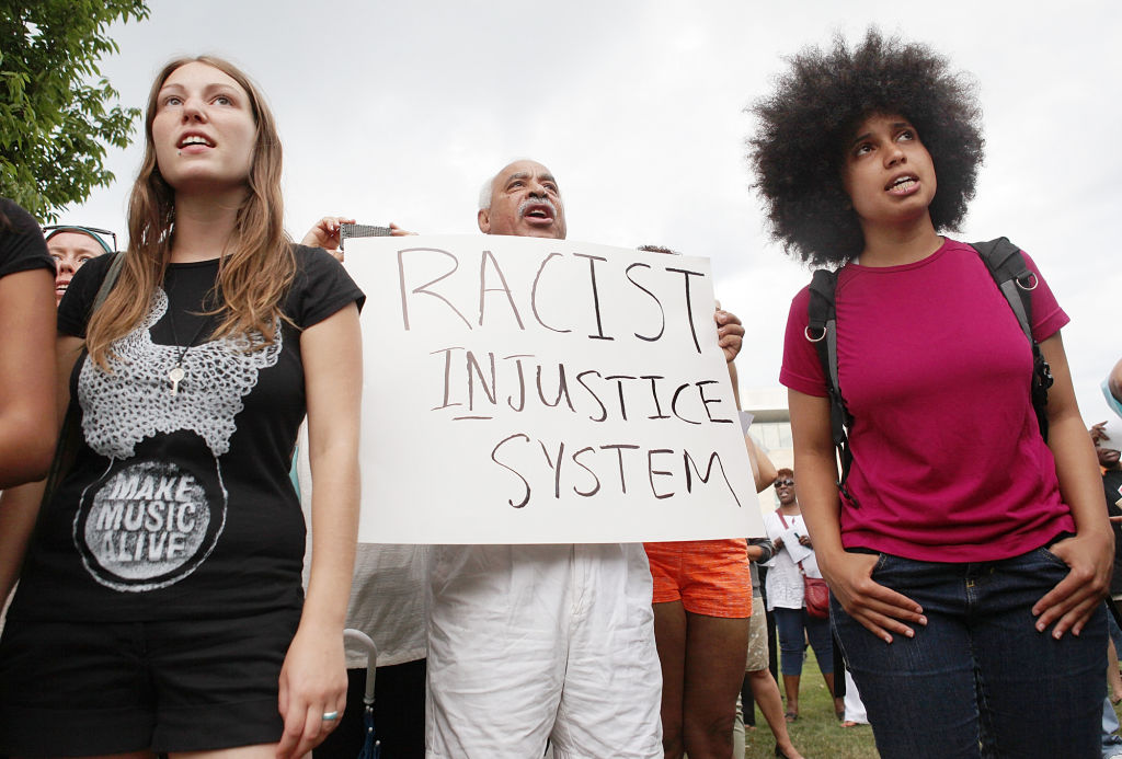 (Boston, MA - 7/14/13) Demonstrators chant ""No justice, no peace,"" during a Dudley Square rally to protest the verdict in the Trayvon Martin case, Sunday, July 14, 2013. Staff photo by Angela Rowlings.