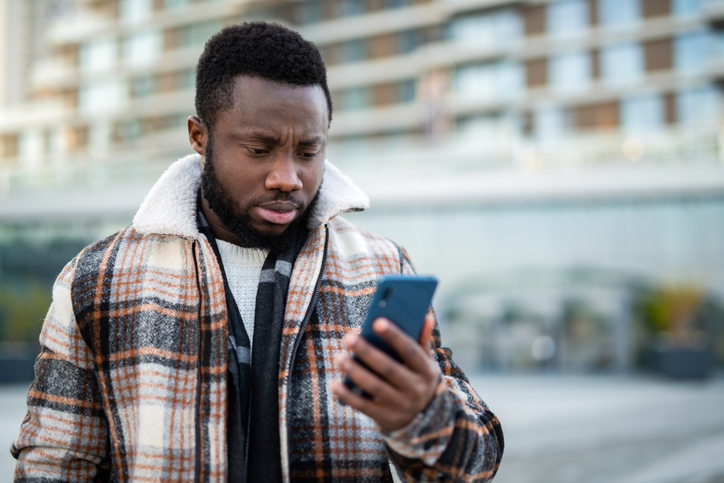 Young man reading a message on a phone.