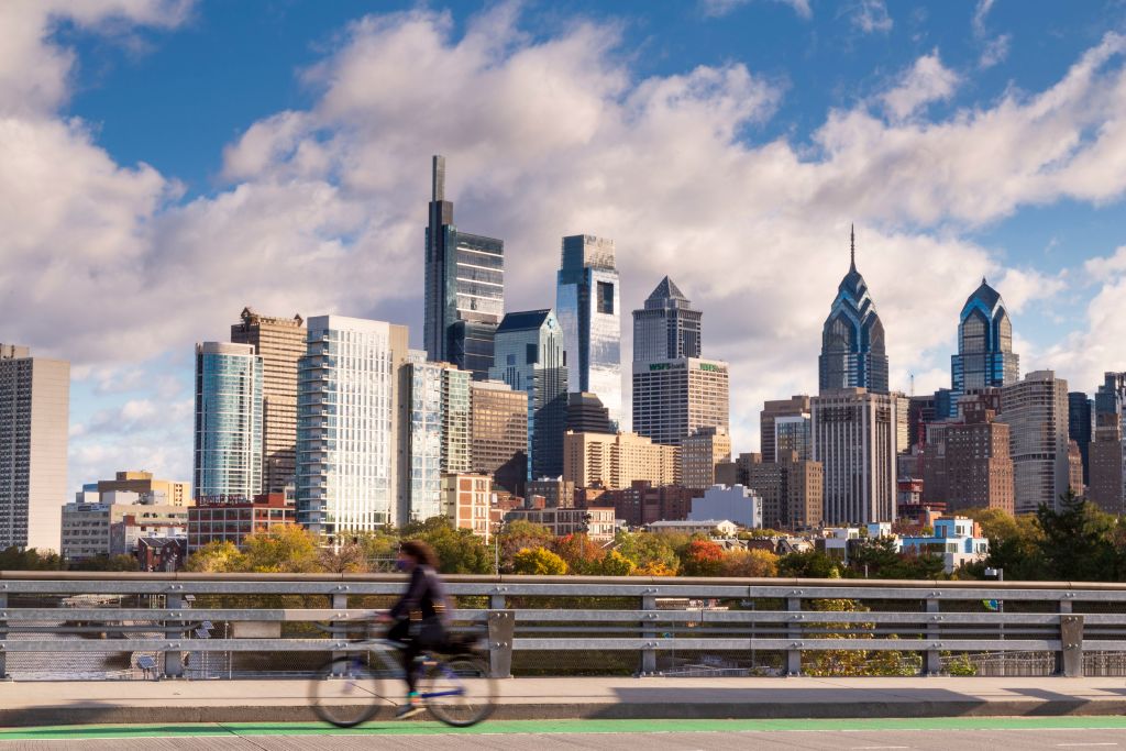 Skyline dengan pengendara sepeda di South Street Bridge di Sunset, Philadelphia, Pennsylvania, AS