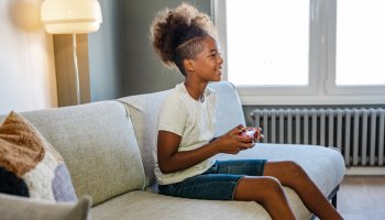 Side view of a teenage girl playing video games