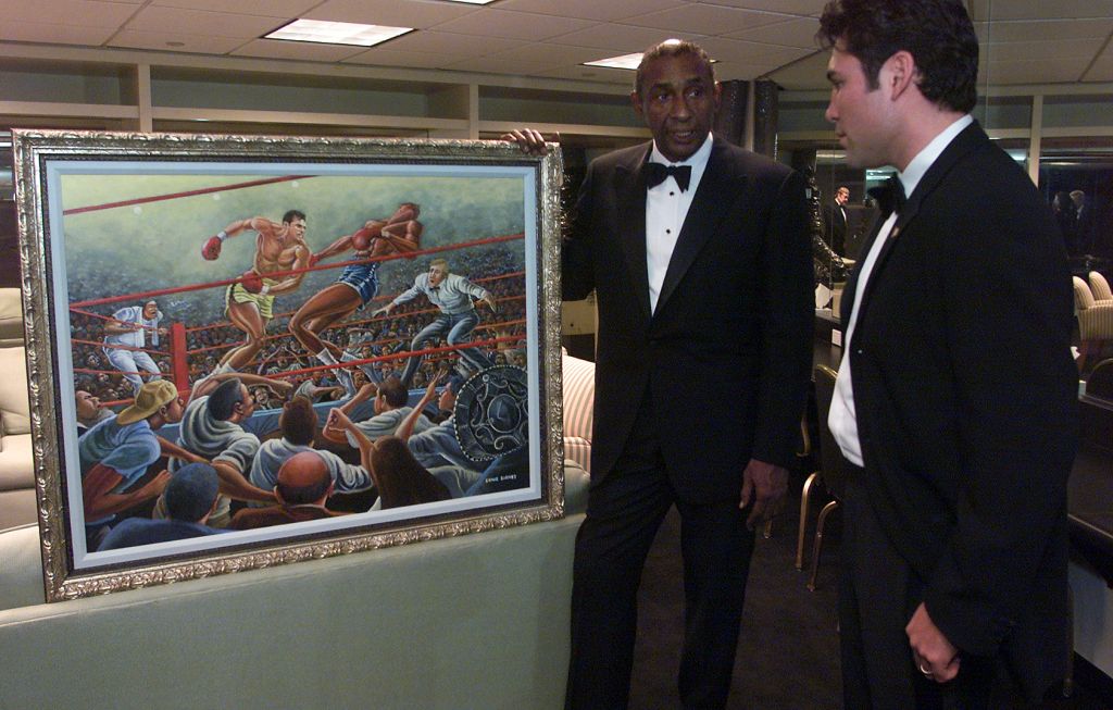 12/12/2001 Ernie Barnes, left, former NFL player now an accomplished artist, shows a painting comm