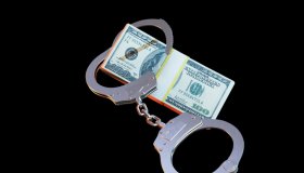 responsibility for corruption. a wad of dollars and handcuffs on a black background. 3D render