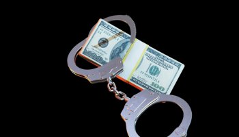 responsibility for corruption. a wad of dollars and handcuffs on a black background. 3D render