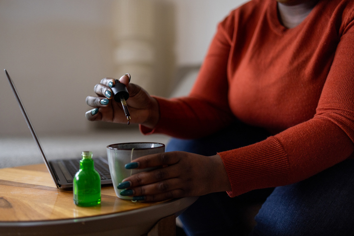 African American plus size woman taking CBD medicine to relax