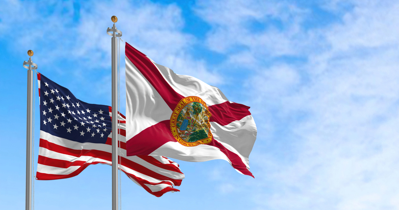 The Florida state flag waving along with the national flag of the United States of America